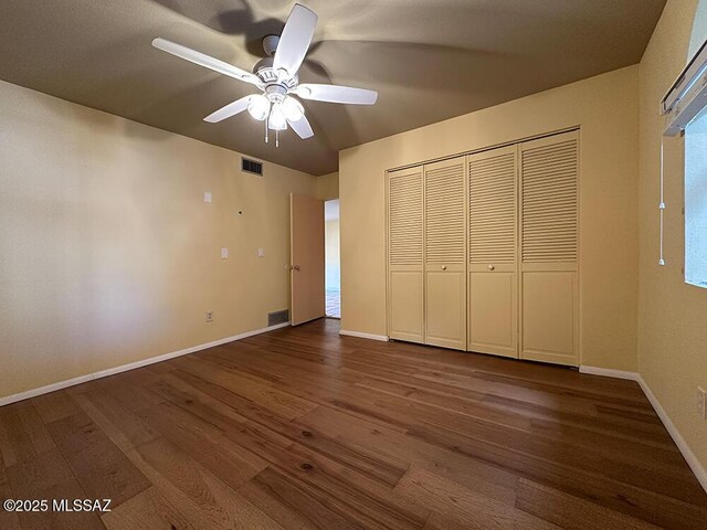 8034 E Shadow Ln, Tucson, AZ 85750 - unfurnished bedroom with dark wood finished floors, a closet, baseboards, and ceiling fan