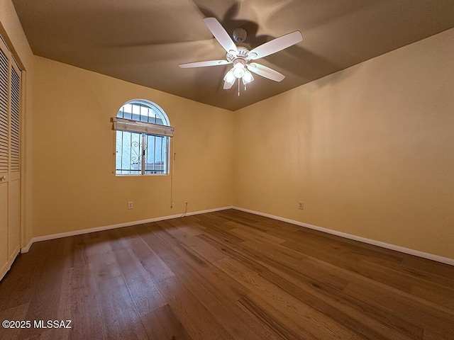 8034 E Shadow Ln, Tucson, AZ 85750 - empty room with dark wood-style flooring, ceiling fan, and baseboards