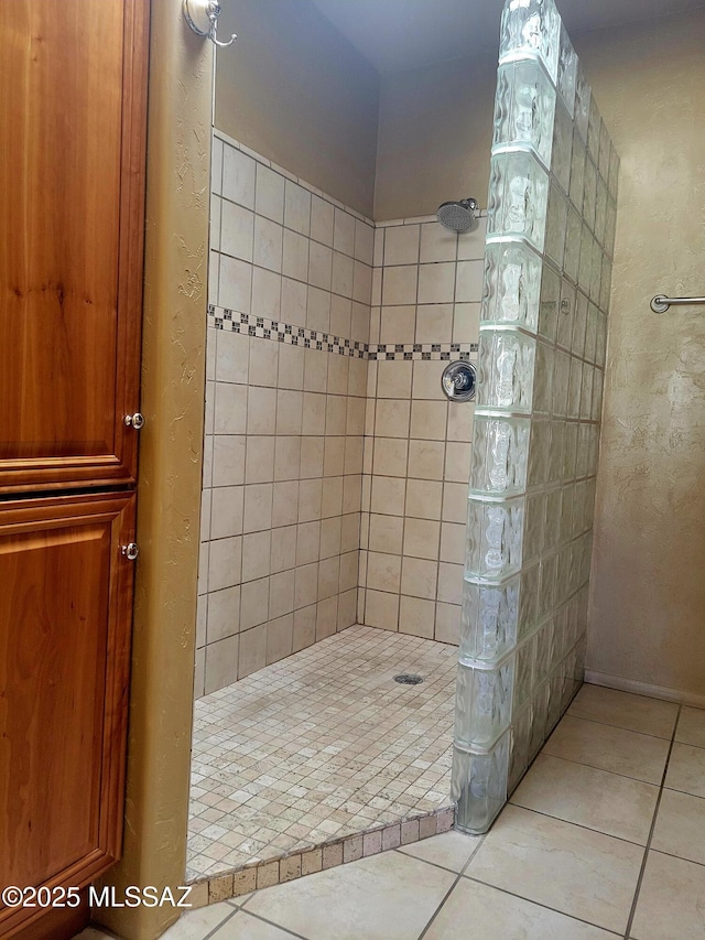 bathroom featuring tile patterned flooring and tiled shower