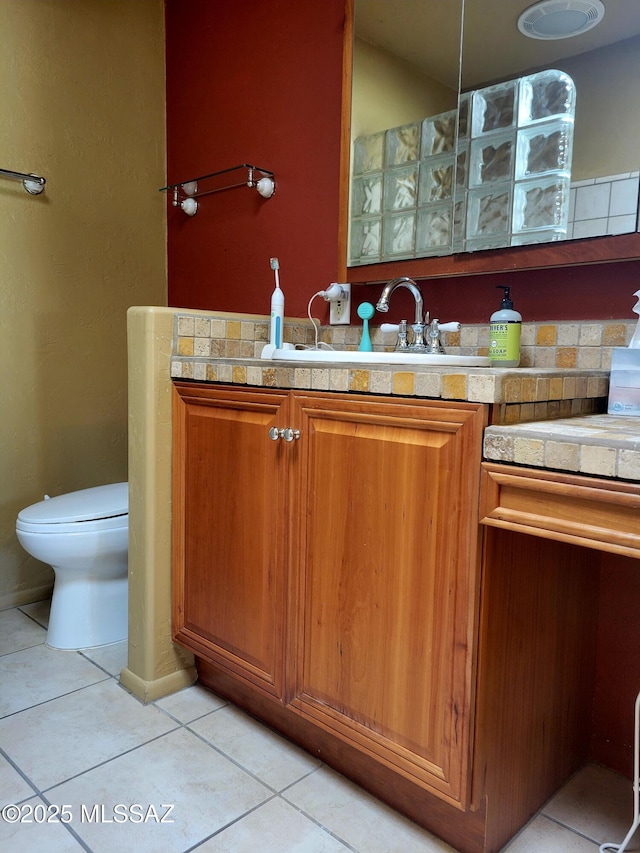 bathroom with tile patterned flooring, vanity, and toilet