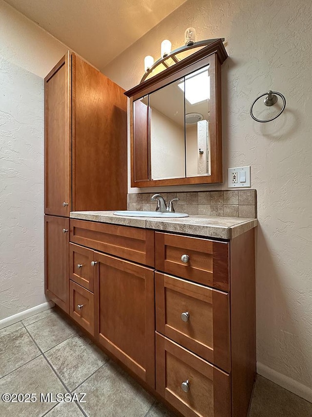 8034 E Shadow Ln, Tucson, AZ 85750 - bathroom with a textured wall, vanity, tile patterned flooring, and baseboards