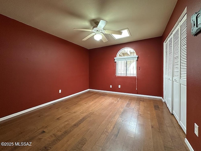 8034 E Shadow Ln, Tucson, AZ 85750 - unfurnished bedroom with hardwood / wood-style flooring, a closet, baseboards, and ceiling fan