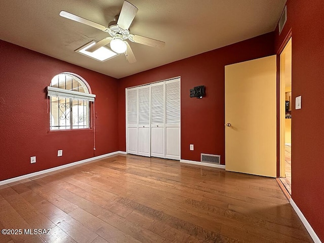8034 E Shadow Ln, Tucson, AZ 85750 - unfurnished bedroom with wood-type flooring, a closet, and baseboards