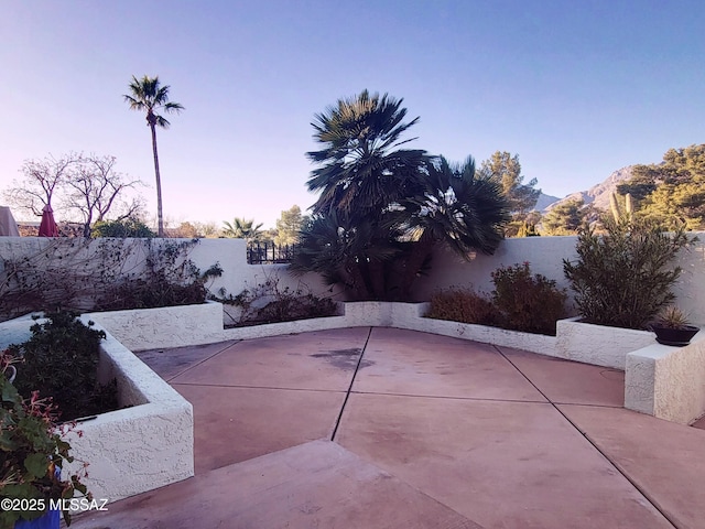 patio terrace at dusk featuring a mountain view