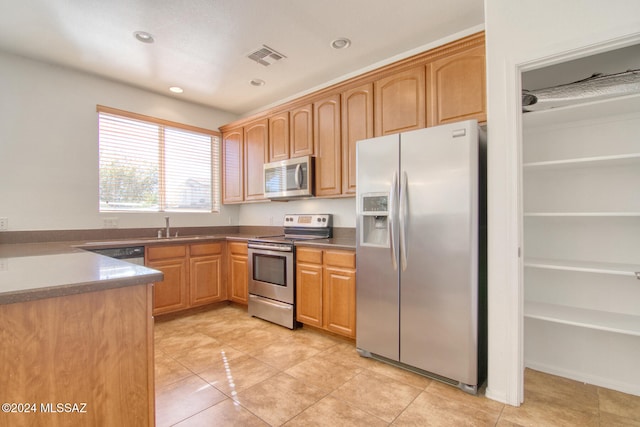 kitchen with sink, stainless steel appliances, and light tile patterned flooring