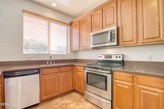 kitchen with sink, light tile patterned floors, and stainless steel appliances