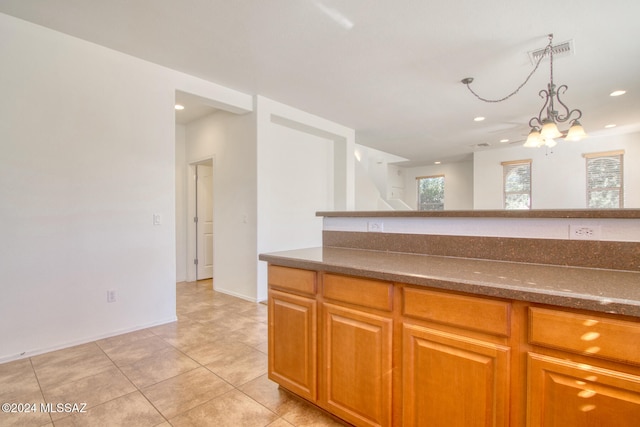 kitchen with light tile patterned floors, hanging light fixtures, and a notable chandelier