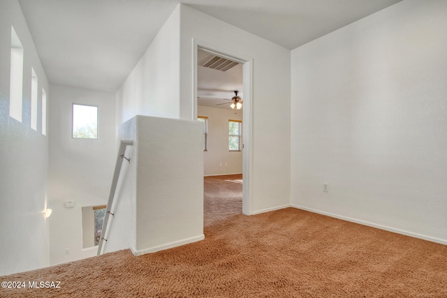 carpeted spare room with a wealth of natural light and ceiling fan