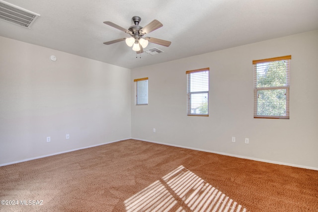 spare room featuring ceiling fan and carpet