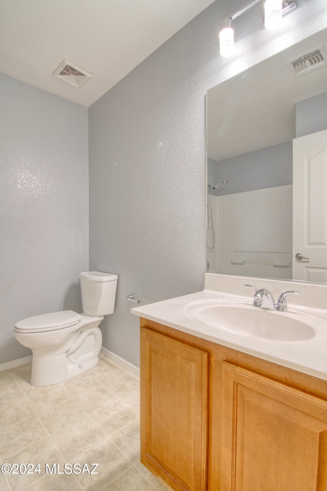 bathroom with vanity, toilet, tile patterned flooring, and walk in shower