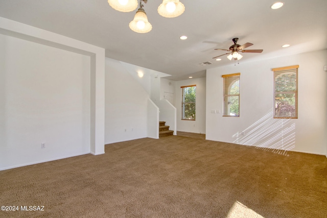 unfurnished living room featuring ceiling fan and carpet floors