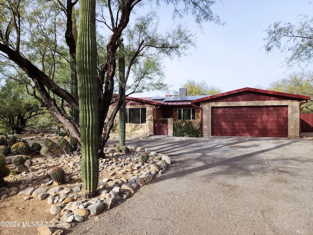 single story home featuring a garage and solar panels