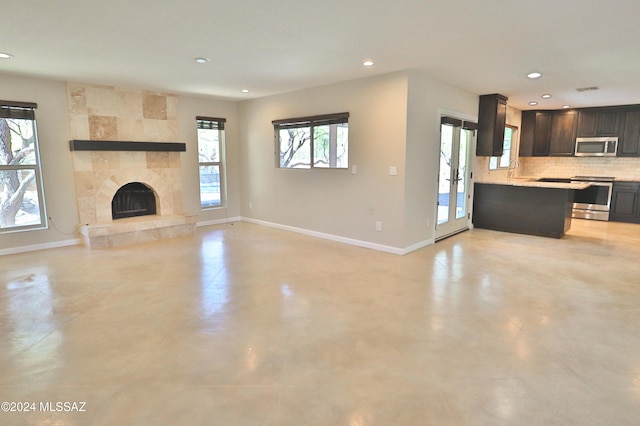 unfurnished living room with sink and a tiled fireplace