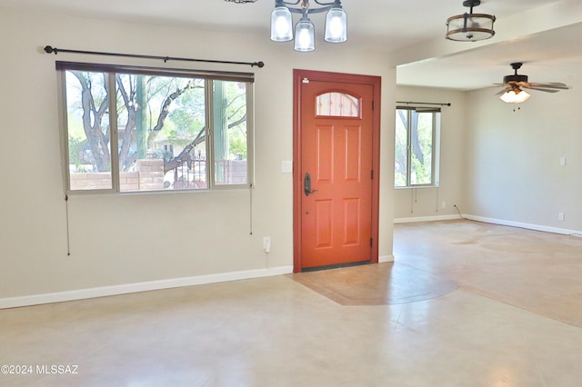 entrance foyer featuring plenty of natural light and ceiling fan with notable chandelier