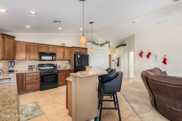 kitchen with lofted ceiling, black appliances, hanging light fixtures, light tile patterned floors, and a kitchen bar