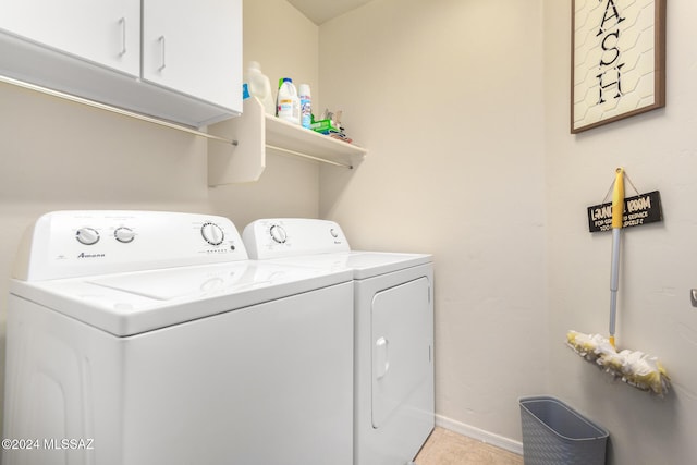 laundry room featuring separate washer and dryer, light tile patterned flooring, and cabinets