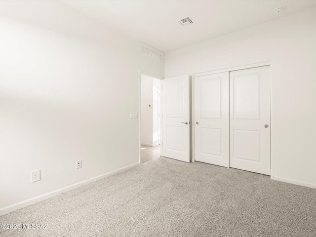 unfurnished bedroom with baseboards, visible vents, and light colored carpet