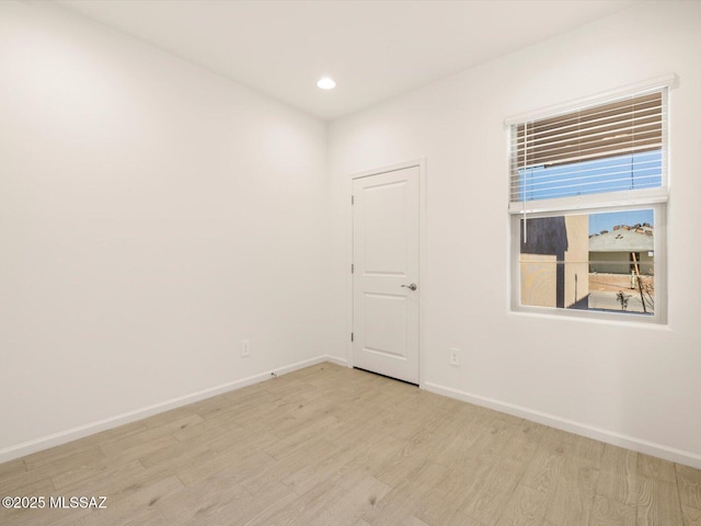 unfurnished room with light wood-style floors, recessed lighting, and baseboards