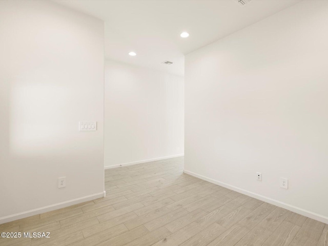 empty room with recessed lighting, baseboards, visible vents, and light wood finished floors