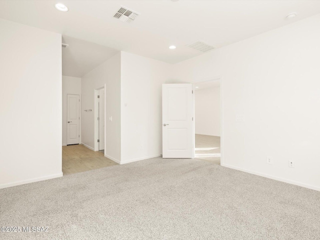 spare room featuring recessed lighting, light colored carpet, visible vents, and baseboards