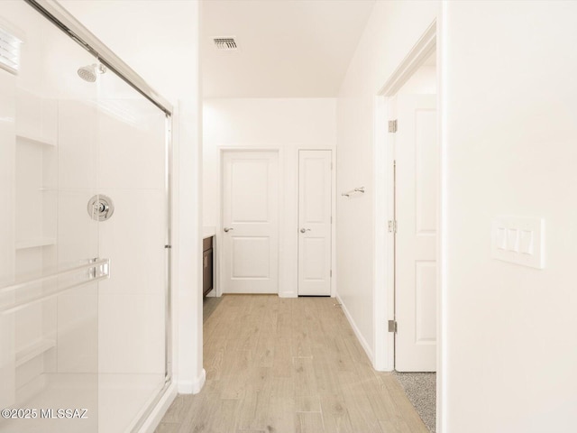 interior space featuring light wood finished floors, baseboards, and visible vents