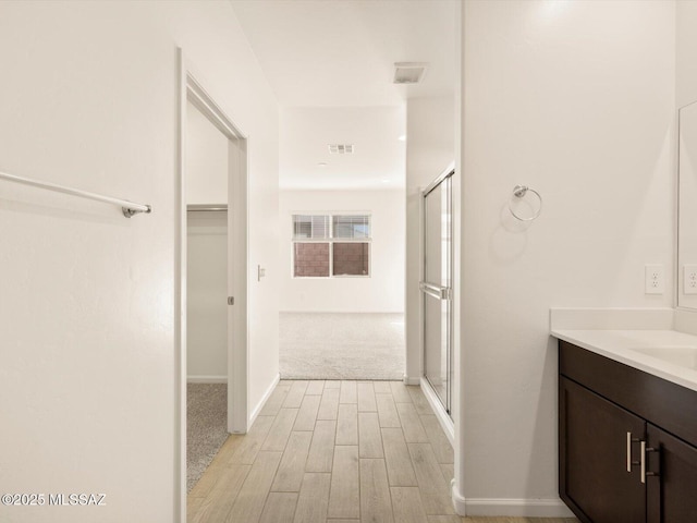 full bathroom with visible vents, wood finished floors, a shower stall, and vanity