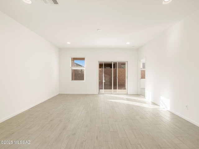 unfurnished room featuring light wood finished floors, baseboards, and recessed lighting