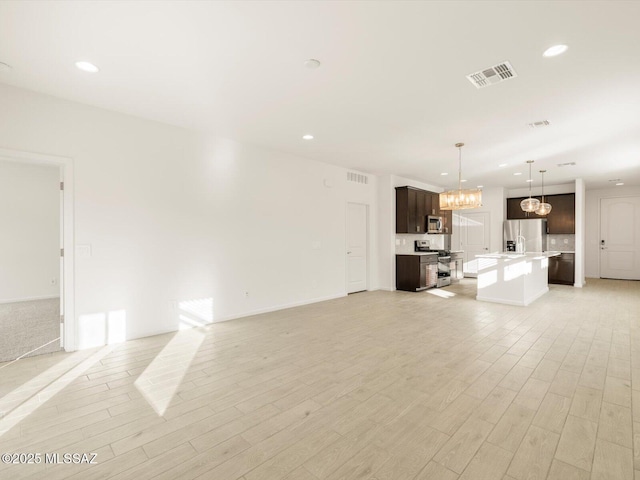 unfurnished living room with recessed lighting, visible vents, and light wood-style flooring