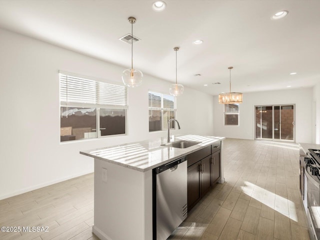 kitchen with stainless steel appliances, a sink, visible vents, wood tiled floor, and a center island with sink