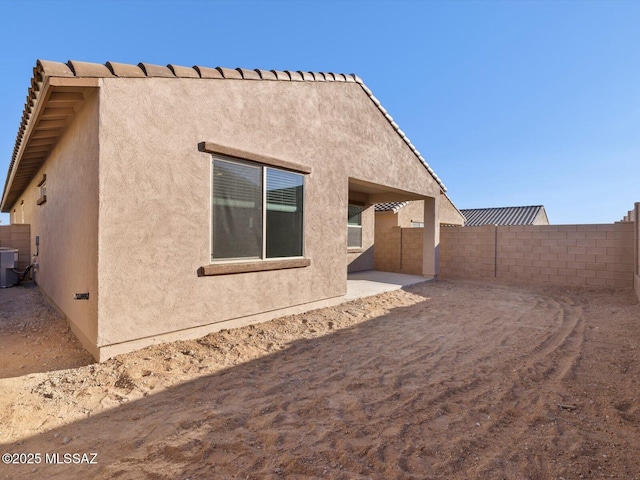 back of property featuring central air condition unit, fence, a patio, and stucco siding