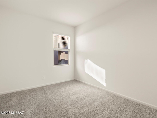 carpeted spare room with baseboards