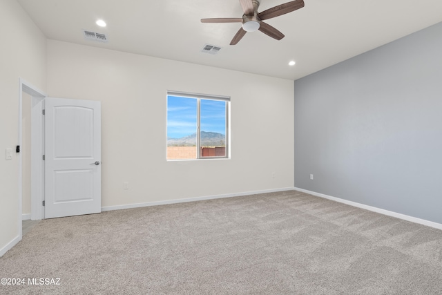 empty room with ceiling fan and light colored carpet