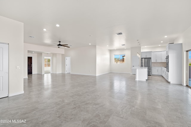 unfurnished living room featuring plenty of natural light, ceiling fan, and light tile patterned floors