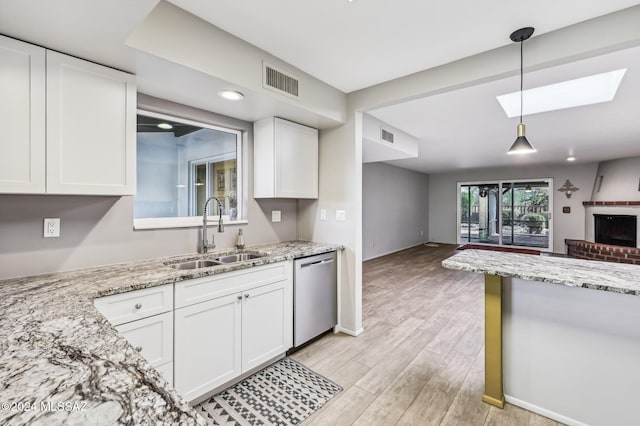 611 S Los Opalos, Green Valley, AZ 85614 - kitchen featuring stainless steel dishwasher, a sink, open floor plan, white cabinets, and a skylight