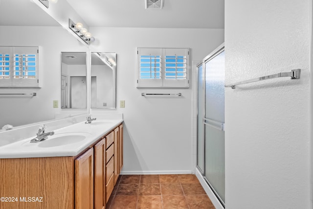 bathroom with tile patterned flooring, vanity, and walk in shower