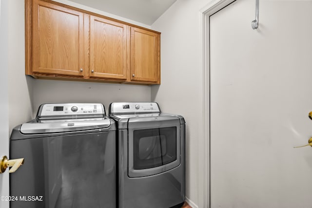 laundry room featuring washing machine and dryer and cabinets