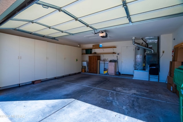 garage featuring heating unit, a garage door opener, and water heater