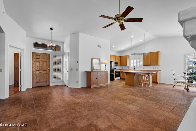 kitchen with pendant lighting, a center island, high vaulted ceiling, ceiling fan with notable chandelier, and a kitchen bar