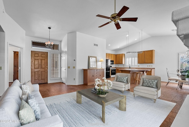 living room with light tile patterned floors, ceiling fan with notable chandelier, high vaulted ceiling, and a healthy amount of sunlight