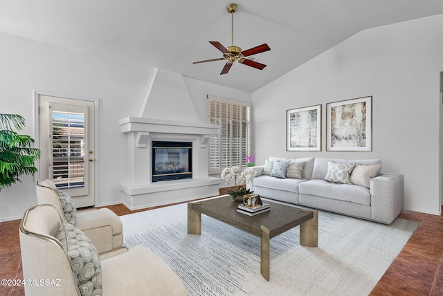 living room featuring hardwood / wood-style flooring, ceiling fan, a fireplace, and vaulted ceiling