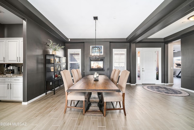 dining space with light hardwood / wood-style floors and a notable chandelier