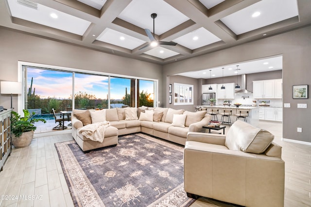 living room featuring beam ceiling, light hardwood / wood-style flooring, and coffered ceiling