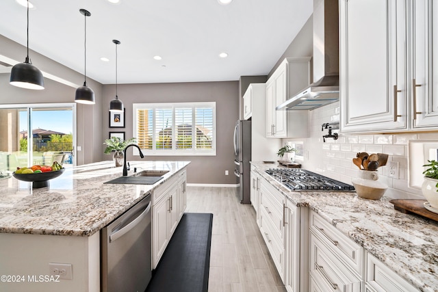 kitchen featuring white cabinets, plenty of natural light, wall chimney exhaust hood, and stainless steel appliances