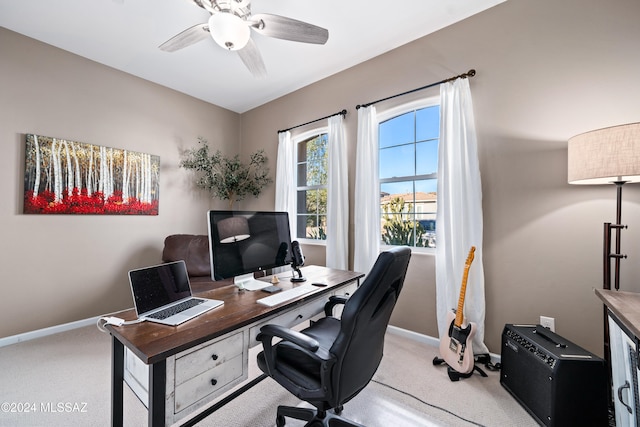 office space featuring light carpet and ceiling fan