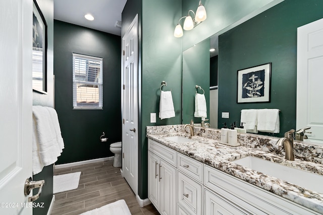 bathroom with hardwood / wood-style floors, vanity, and toilet