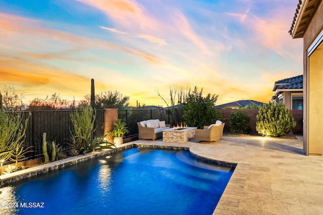 pool at dusk featuring a patio and an outdoor hangout area