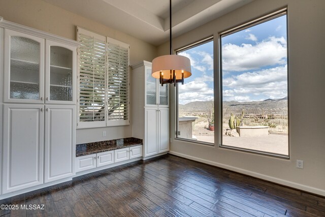 dining area with a mountain view, dark hardwood / wood-style floors, and a notable chandelier