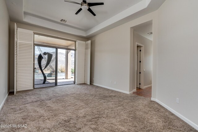 carpeted bedroom featuring ceiling fan, access to outside, and a tray ceiling