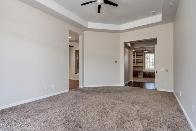 bedroom with a raised ceiling, ensuite bath, ceiling fan, and light colored carpet