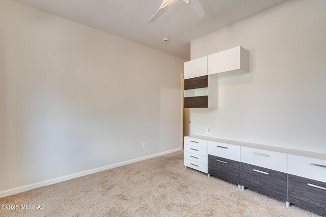 carpeted home office featuring ceiling fan